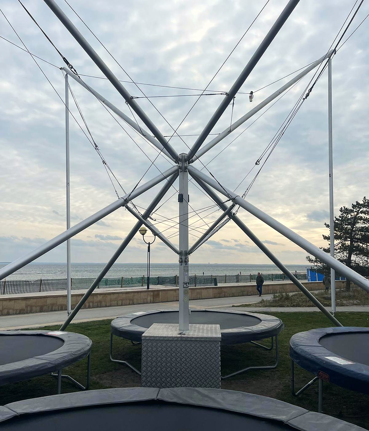 Bungee-Gestell mit Trampolinen vor Strandpromenade und Ostsee